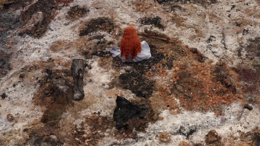 Aerial view of a woman sitting on rocky ground