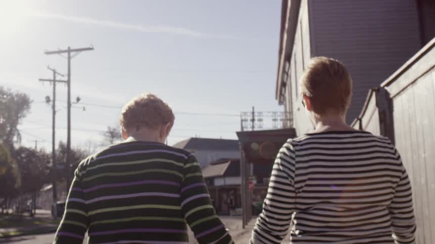 Two women walk down a street together