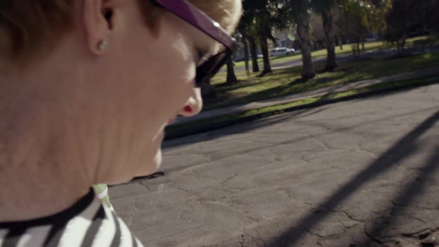 Two older women walking down a street on sunny day