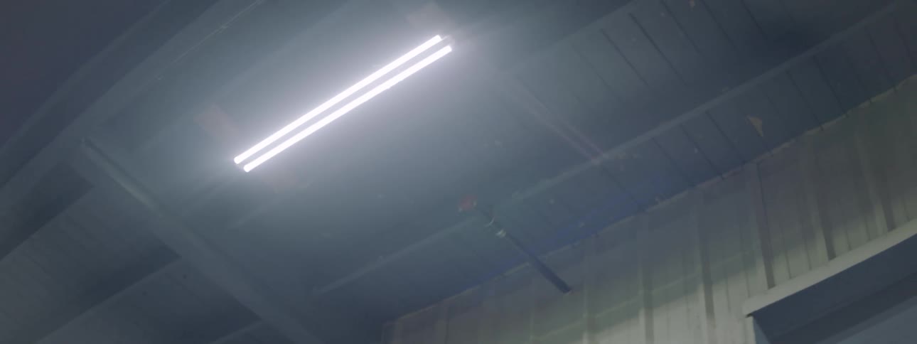 An overhead light fixture on a gray ceiling
