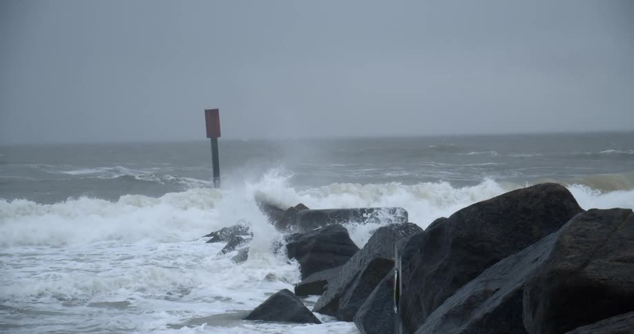 A rocky coast with waves with the ocean sky and clouds in the background
