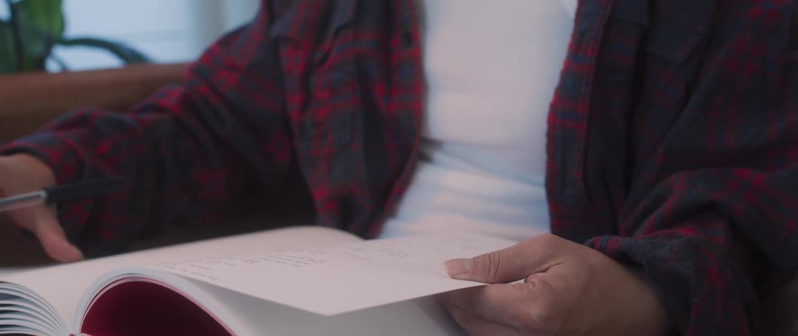 A teenage girl reading a book at home