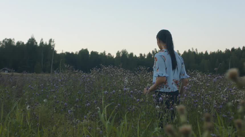 A woman walks through a field