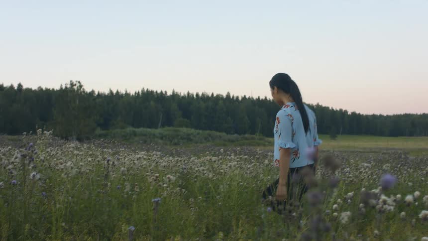 Woman walking through flower field