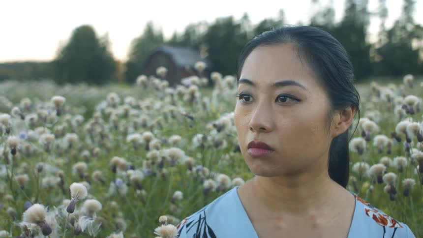 A woman is standing in a field of flowers