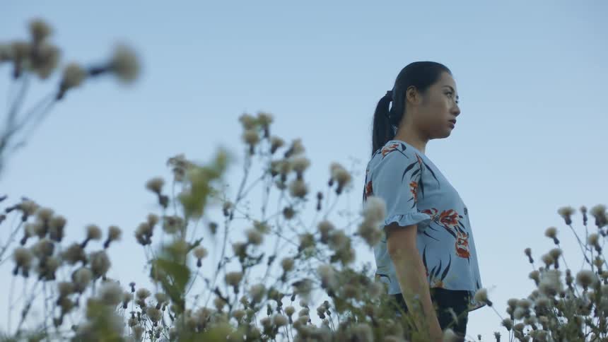A woman is standing outdoors in spring