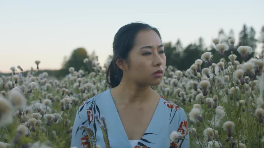 A young woman sitting in a field of flowers