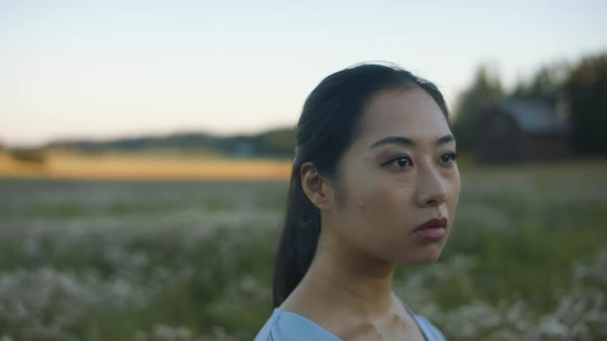 A young woman standing in a field of flowers