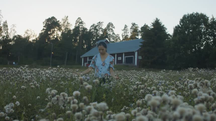 Woman practicing tai chi in a field full of flowers