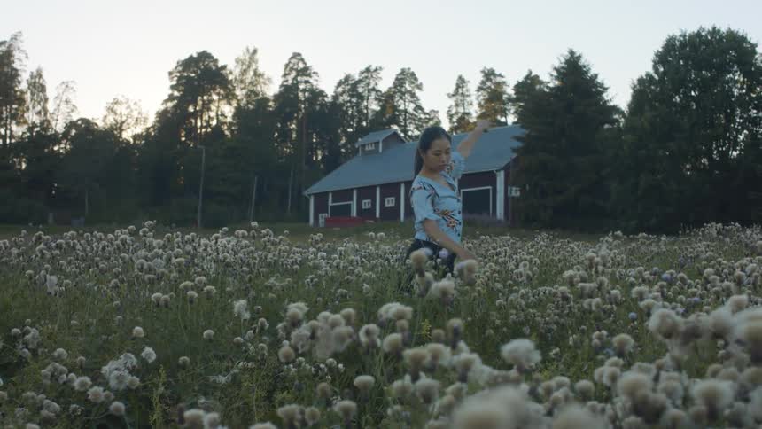 A woman is dancing in a field of flowers