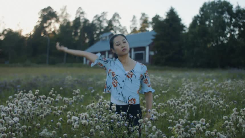 A woman is standing in a field of flowers