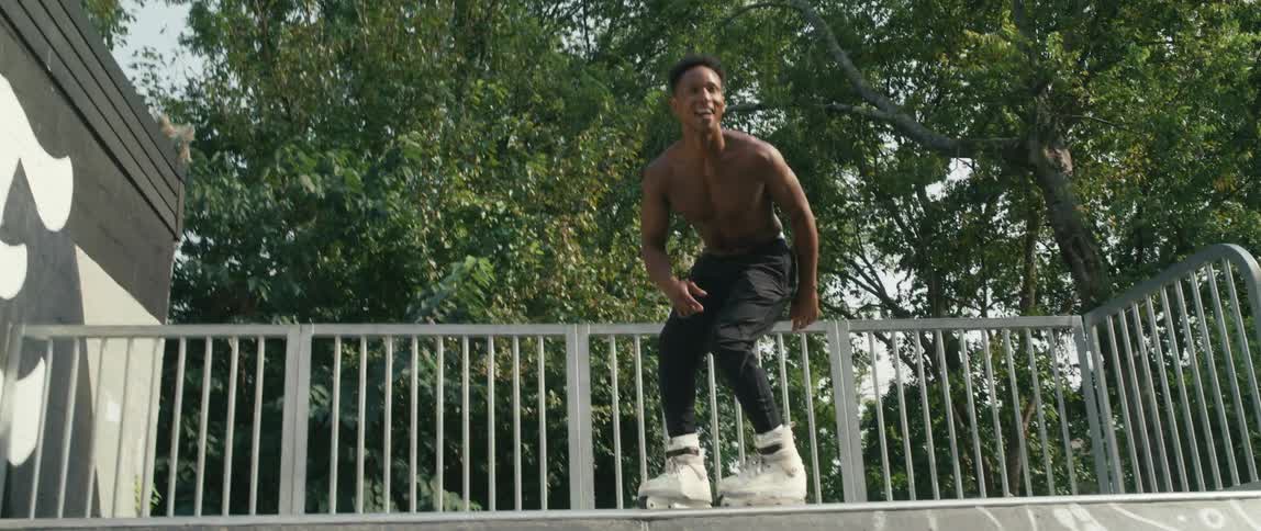 A man is roller blading in a park in spring