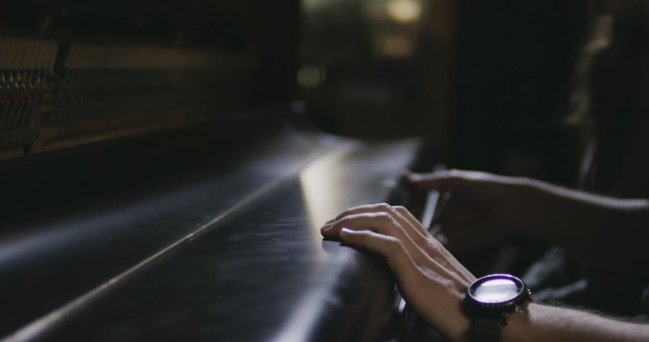 A man closing the lid over piano keys