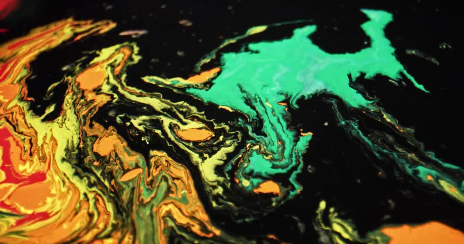 Bright liquid ink over a surface forming chaotic psydhedelic patterns