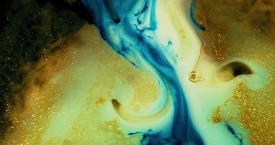 Foamy blue cream and gold liquids mixing together