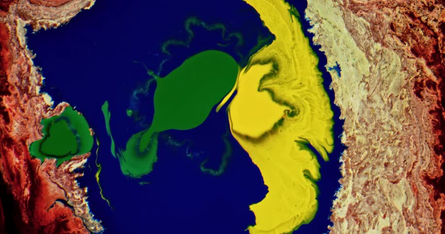 Bright colorful inks spreading over a surface forming chaotic patterns