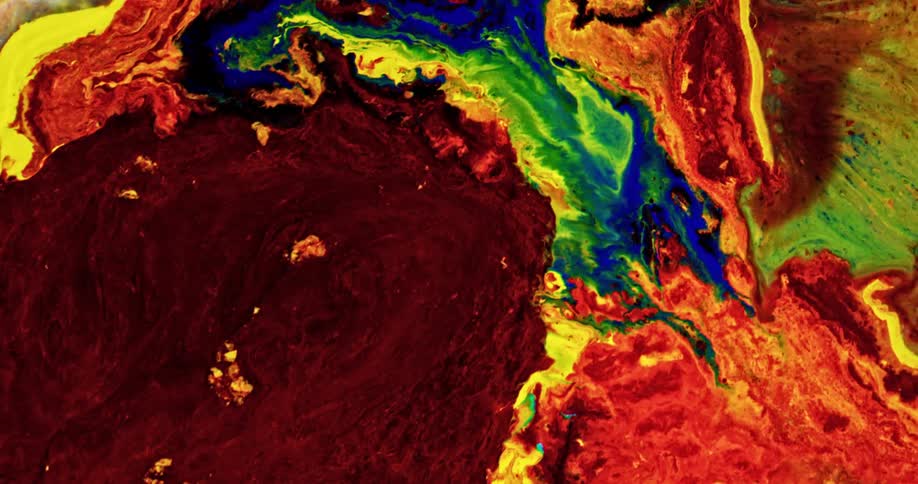 Bright colorful liquid ink flowing over a surface forming chaotic psychedelic patterns