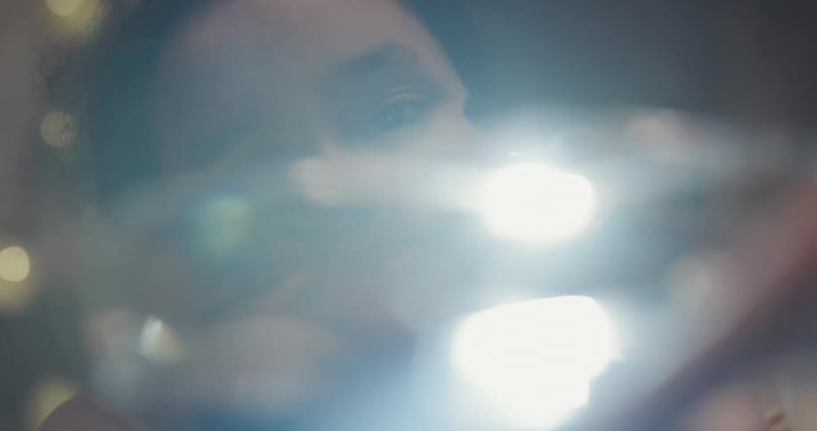 A black girl holds a piece of glass and turning a light on it