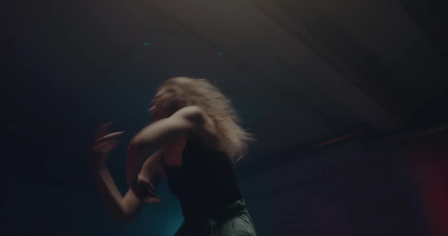 Woman dancing alone in a dark room