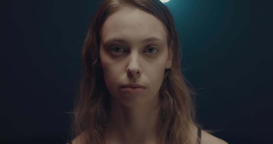 Woman in a dark room blink and staring