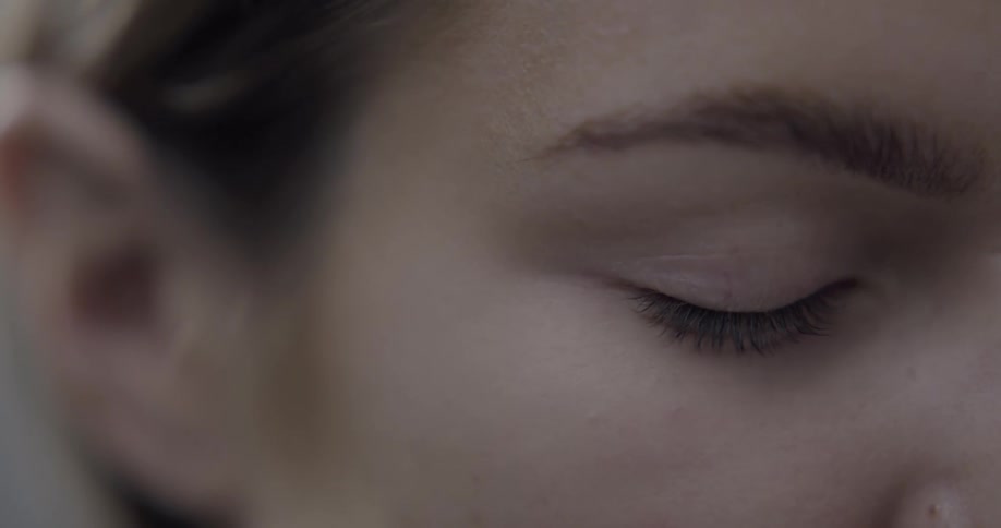 A woman is posing for the camera with her eyes tightly shut