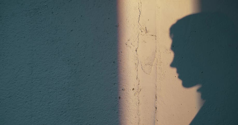 The shadow of a persons head is visible on the wall