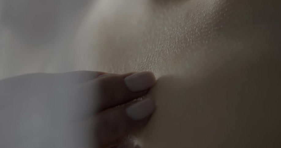 Woman touching her chest with the tip of her fingers