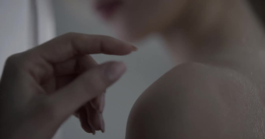 A woman in a room touching a curtain
