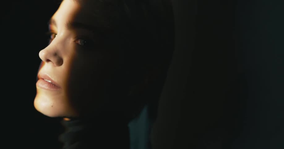 A woman slightly lit with a streak of light