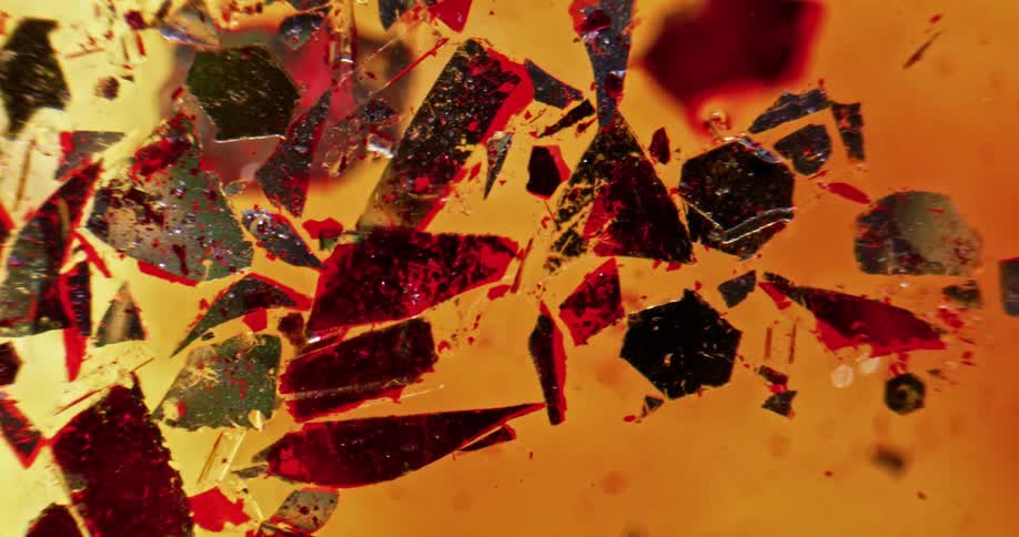 Broken glass shards floating in orange liquid
