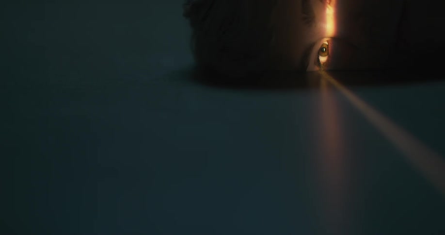 A teenage boy sleeps on the ground opens his eyes as the sunlight hits him