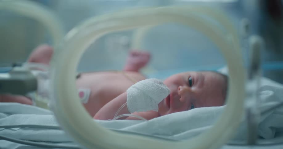 A close up of a baby in an incubator
