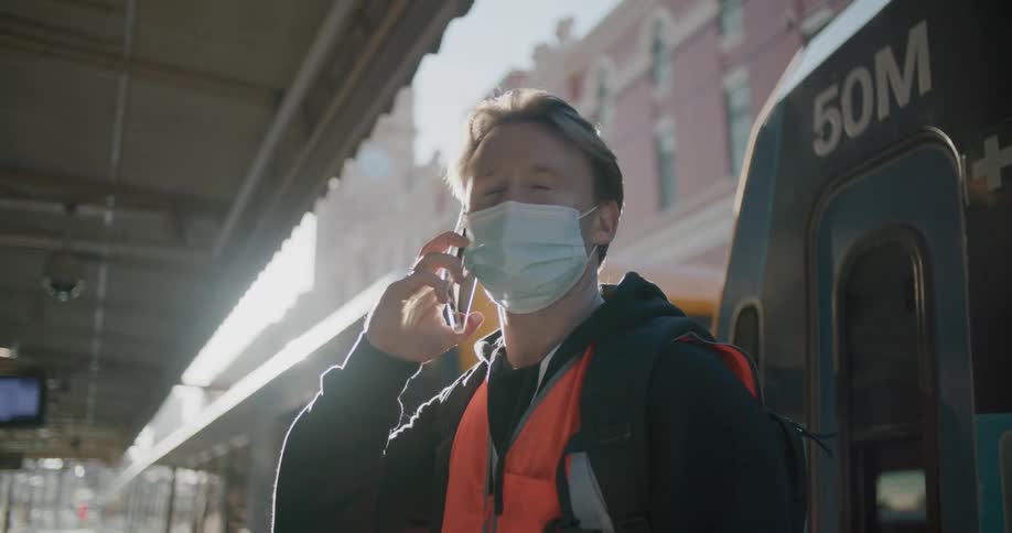 A man talks on his cell phone by the bus
