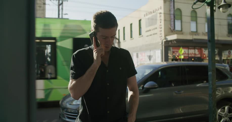 Young man talking on the smartphone on the street of the city downtown