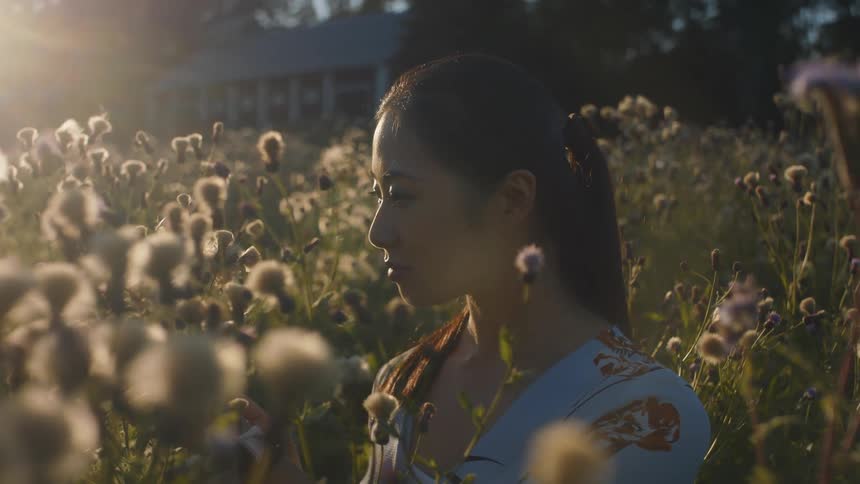A woman is sitting in a field of flowers