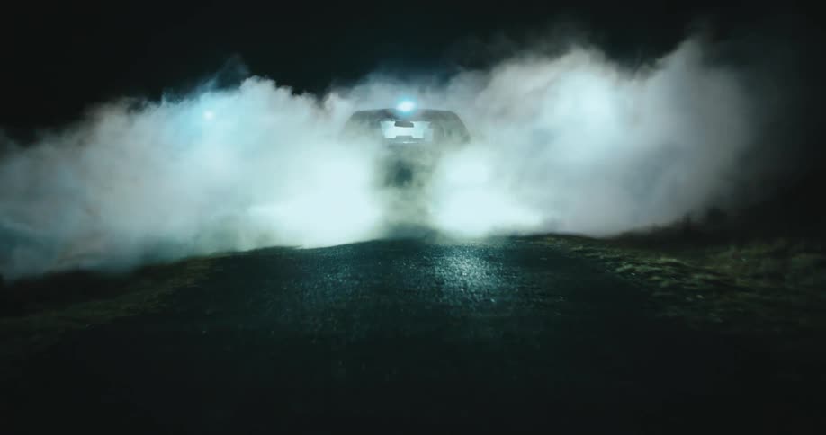 Car with headlights on parked on a road and concealed in mist with three lights turning on behind it