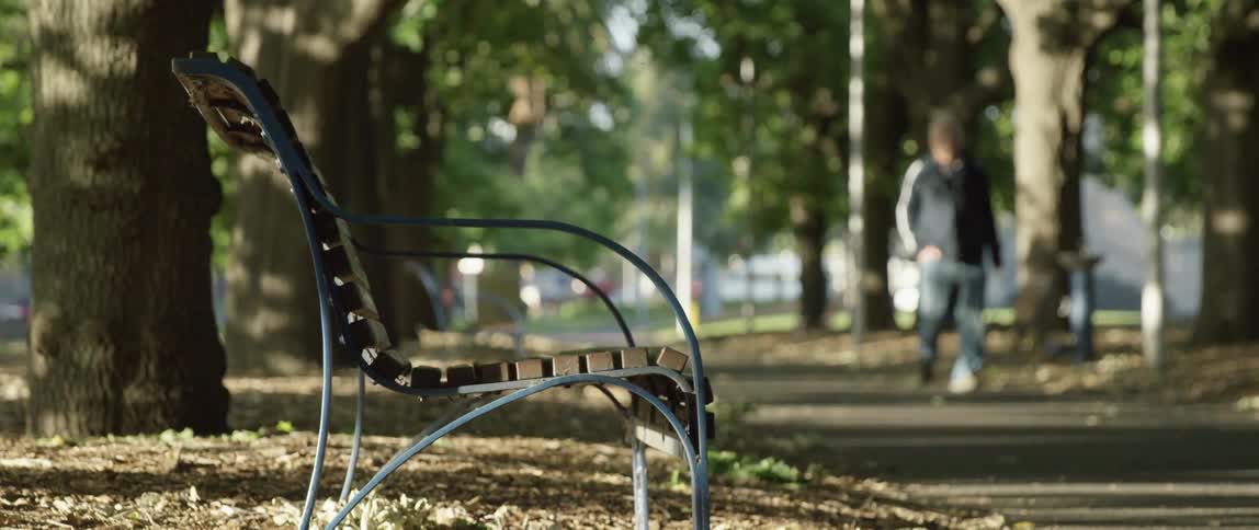 A metal bench in a public park on the city at morning