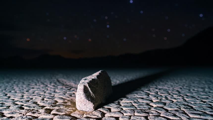 Computer generated images of lights moving around a rock in the desert at night