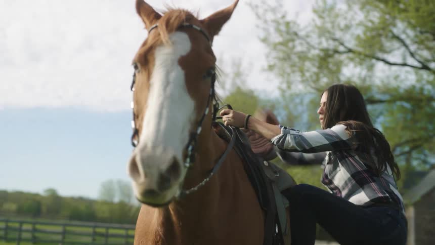 A woman is riding a horse in spring