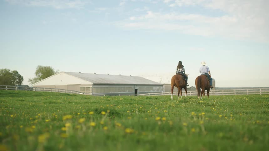 Two people riding horses