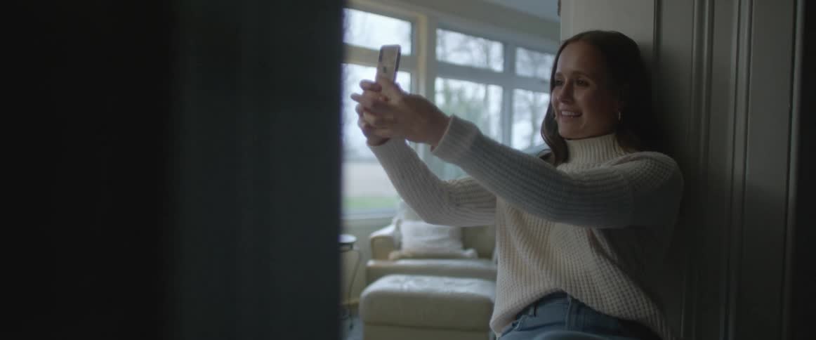 A woman taking a selfie with her phone