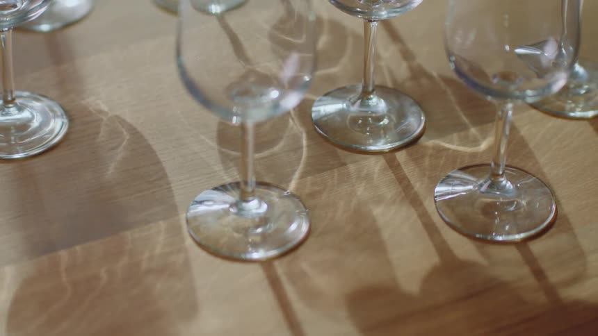 A wine glass being picked up among a group of wine glasses