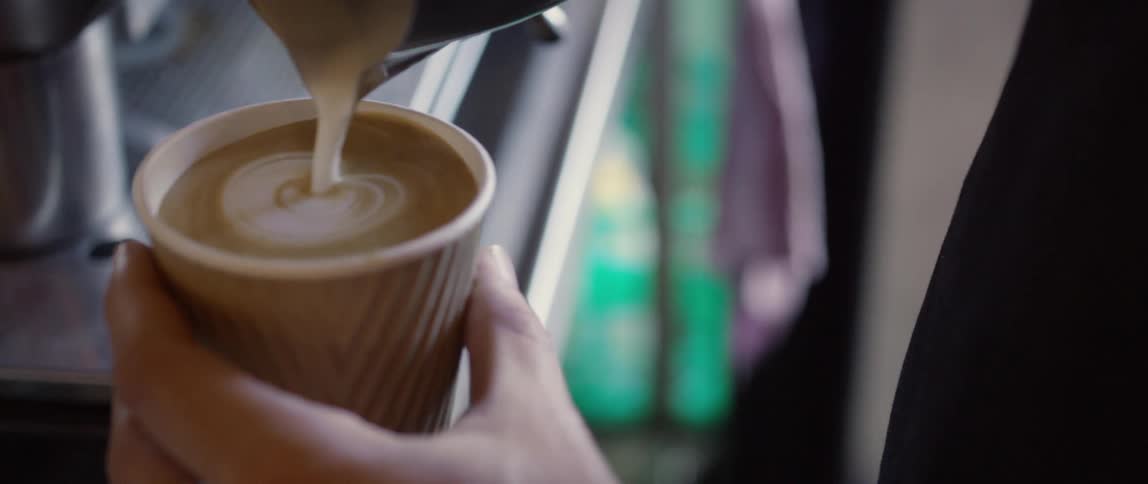 A person is pouring a cup of coffee during the day