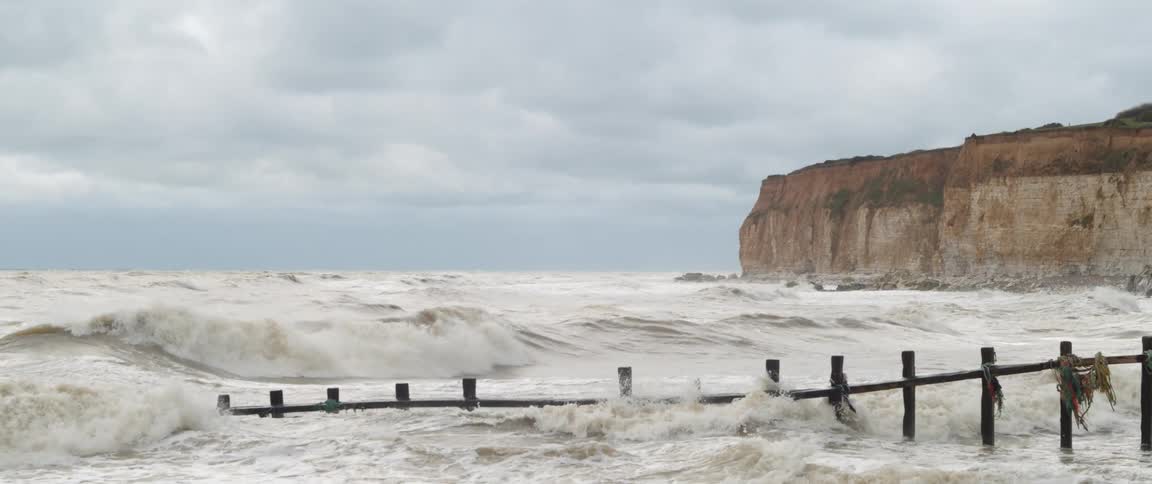 Ocean waves washing ashore a beach on a cloudy day