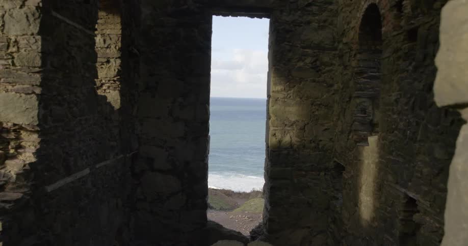 Inside a stone ruin structure overlooking a beach