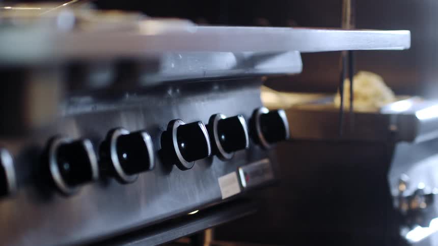 Sunlights reflects off a stainless steel stove top in a restaurant kitchen