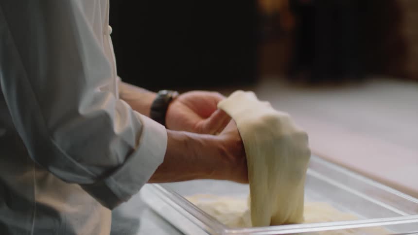 Man tossing dough inside container