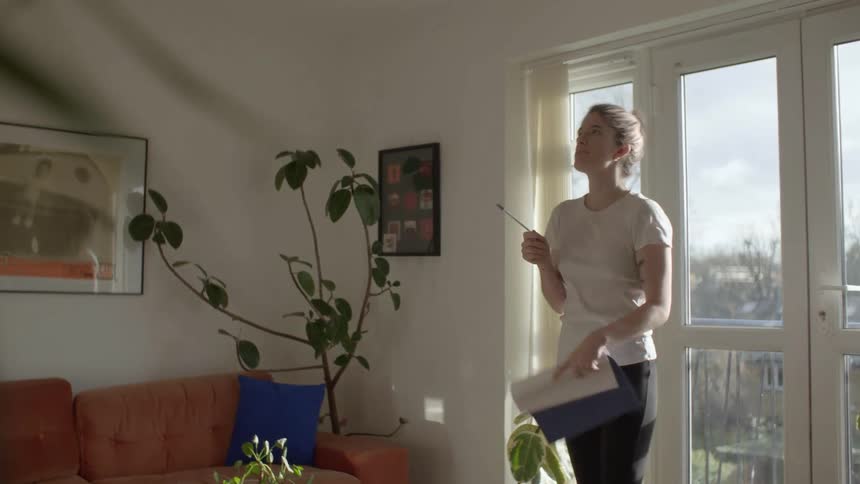 A woman is walking around her house during the day