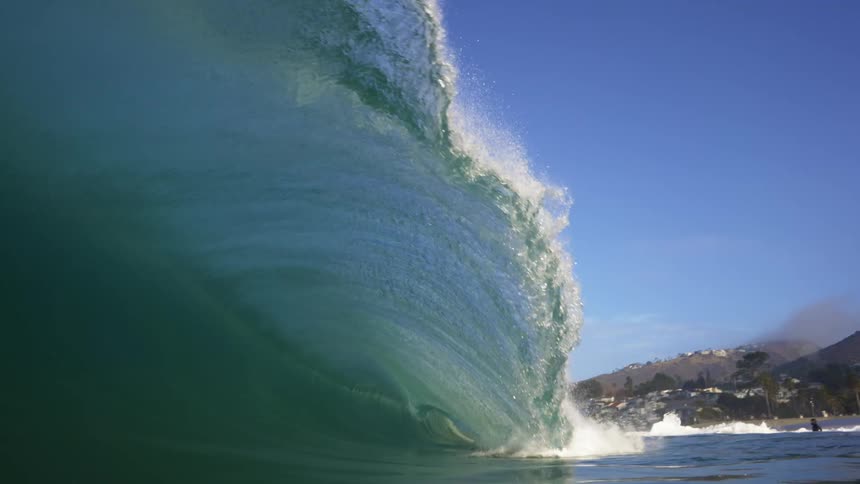 A large ocean wind wave at daytime cascades forwards and submerged the camera underwater