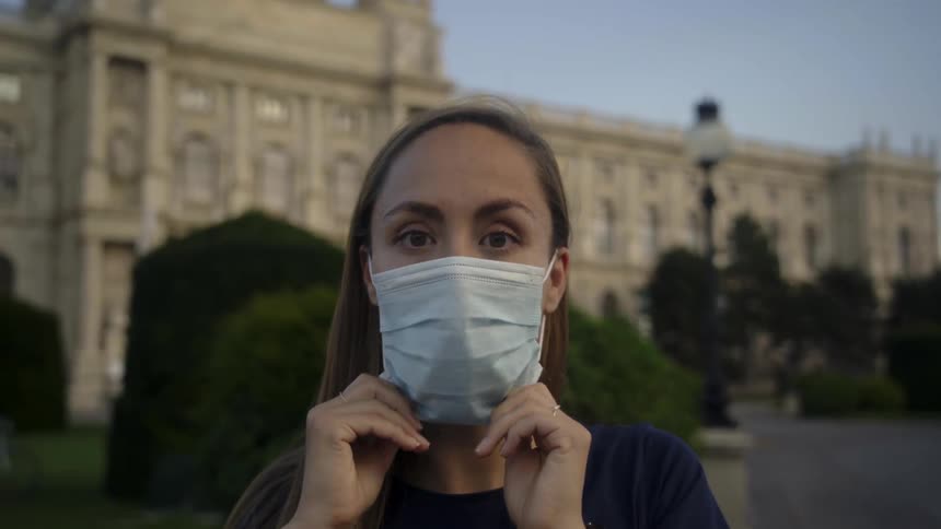 A woman putting on a mask